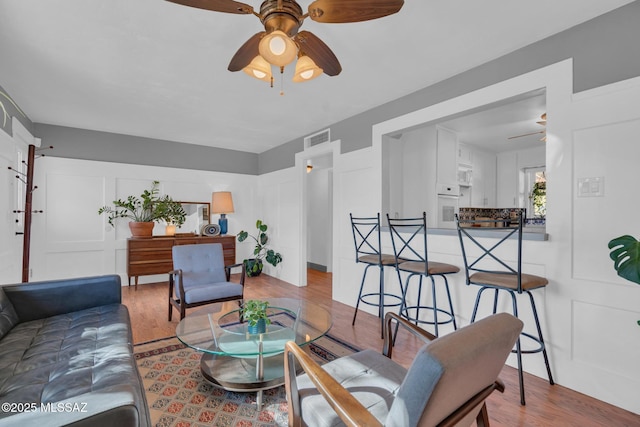 living room with light wood-type flooring and ceiling fan