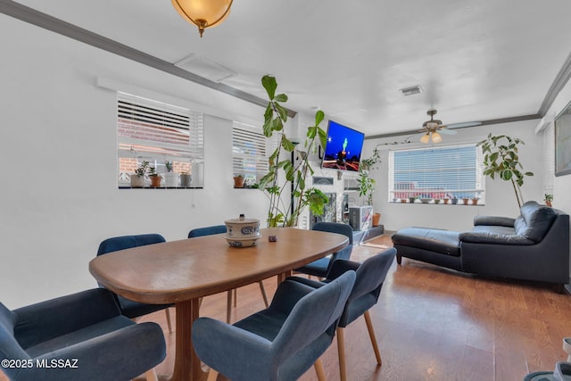 dining area with ceiling fan, wood-type flooring, and ornamental molding