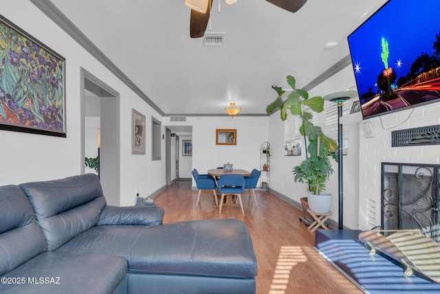 living room featuring ceiling fan, wood-type flooring, and ornamental molding