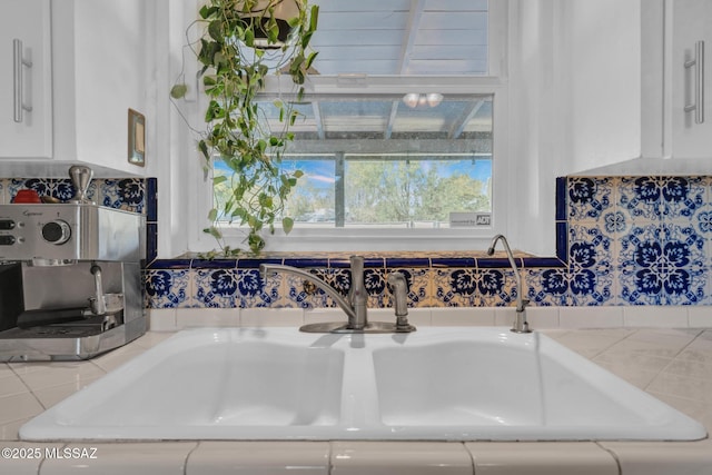 kitchen featuring sink and white cabinets