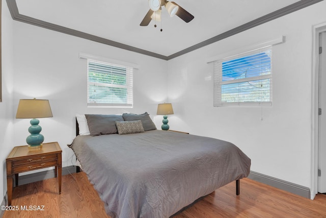 bedroom with hardwood / wood-style floors, ornamental molding, ceiling fan, and a baseboard heating unit