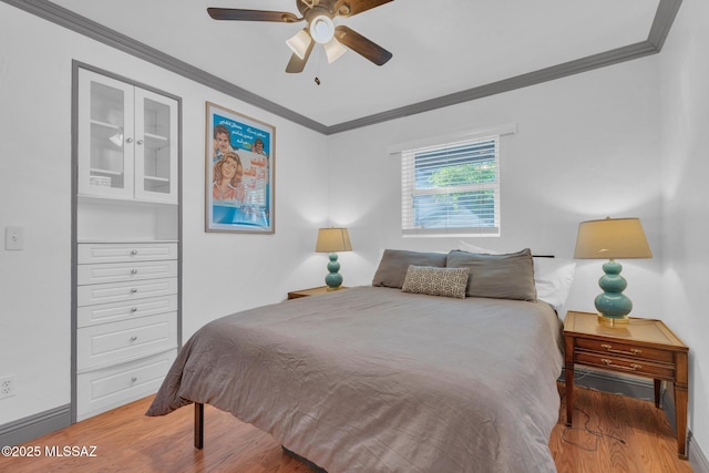 bedroom with ceiling fan, wood-type flooring, and ornamental molding