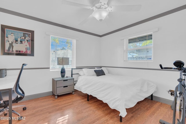 bedroom featuring multiple windows, crown molding, ceiling fan, and light wood-type flooring