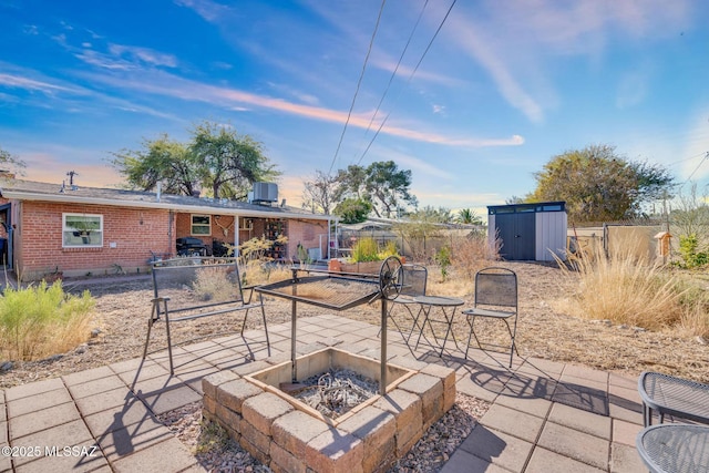 patio terrace at dusk with a shed and a fire pit