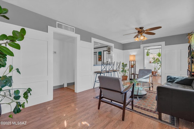 living room with hardwood / wood-style flooring and ceiling fan