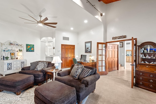 living room featuring ceiling fan, a high ceiling, and french doors