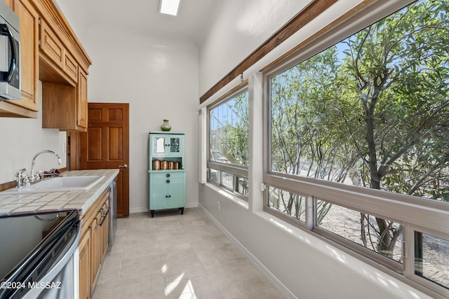 kitchen with tile countertops, sink, and a healthy amount of sunlight