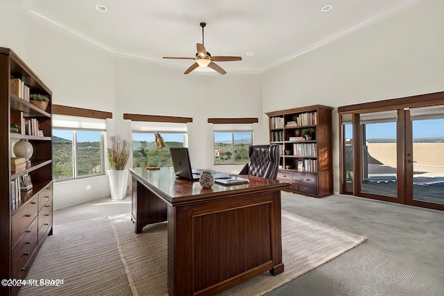 office space featuring ceiling fan, french doors, light colored carpet, and a high ceiling