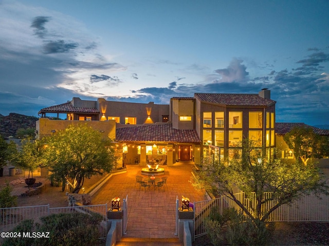 back house at dusk with a patio