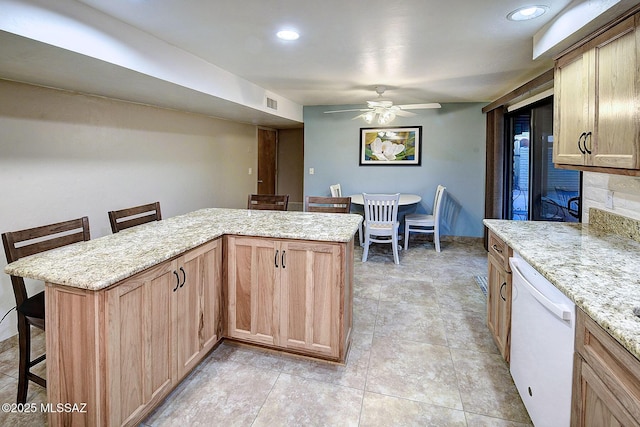 kitchen with a kitchen breakfast bar, ceiling fan, dishwasher, and light brown cabinets