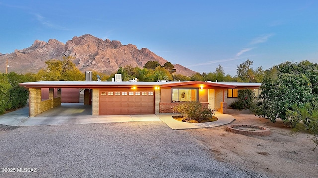 ranch-style home with a carport, a mountain view, and a garage