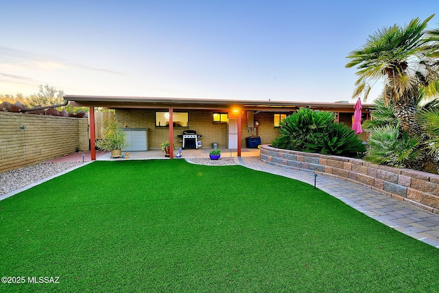 ranch-style house with a yard and an outdoor kitchen