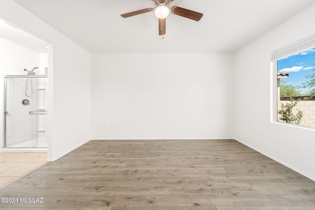 empty room with ceiling fan and light wood-type flooring