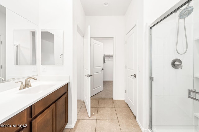 bathroom with tile patterned floors, a shower with door, and vanity