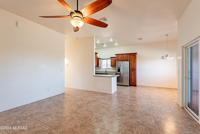 unfurnished living room featuring ceiling fan with notable chandelier