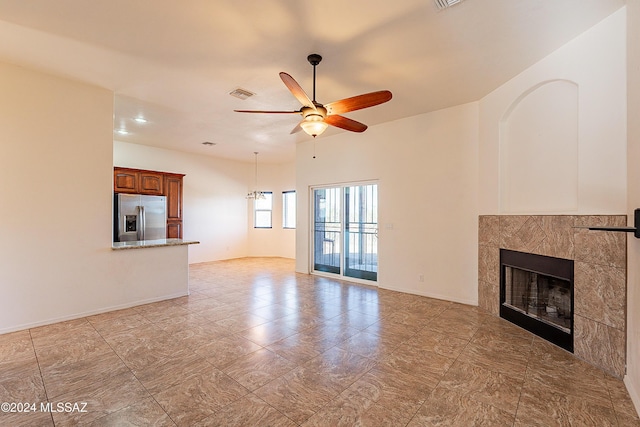 unfurnished living room with ceiling fan and a fireplace