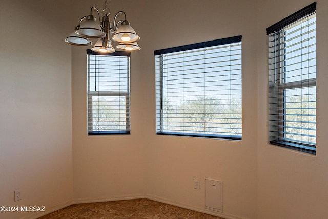 empty room with an inviting chandelier and a wealth of natural light