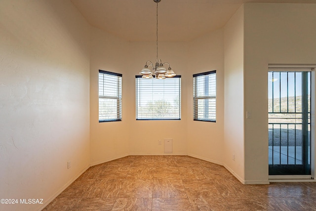 spare room featuring a high ceiling and a notable chandelier