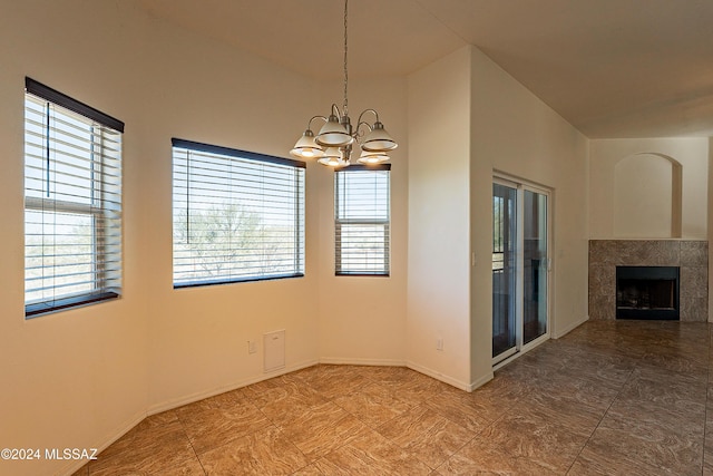 empty room with a fireplace and a notable chandelier