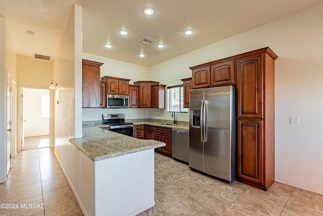 kitchen with kitchen peninsula, appliances with stainless steel finishes, light stone counters, sink, and light tile patterned flooring