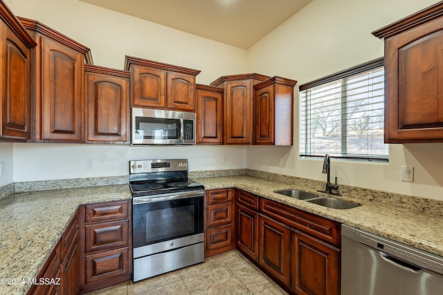 kitchen with light stone countertops, stainless steel appliances, vaulted ceiling, sink, and light tile patterned flooring