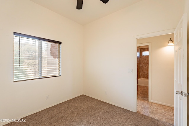 carpeted spare room featuring ceiling fan