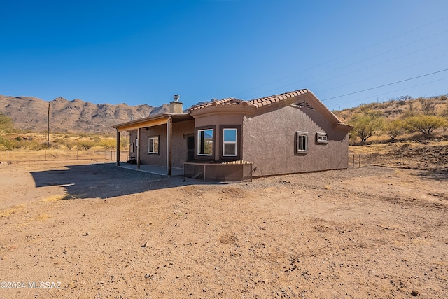 back of property featuring a mountain view and a wall mounted air conditioner