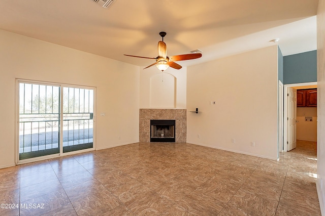 unfurnished living room featuring a tile fireplace and ceiling fan