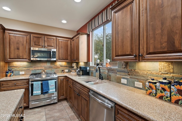 kitchen with tasteful backsplash, light stone countertops, sink, and stainless steel appliances