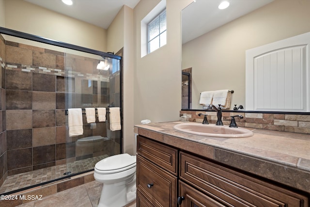 bathroom featuring an enclosed shower, vanity, toilet, and tile patterned flooring