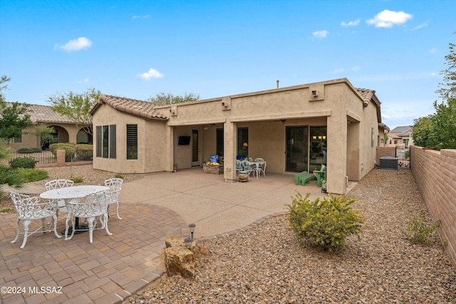 rear view of property featuring a patio and central AC