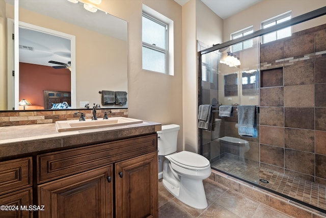 bathroom with vanity, tile patterned flooring, ceiling fan, toilet, and walk in shower