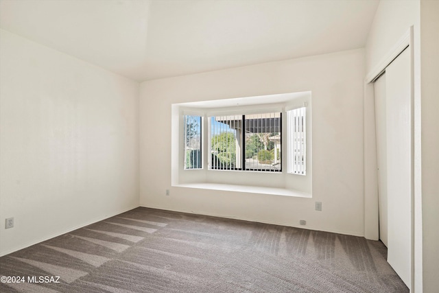 unfurnished bedroom with light carpet, a closet, and high vaulted ceiling