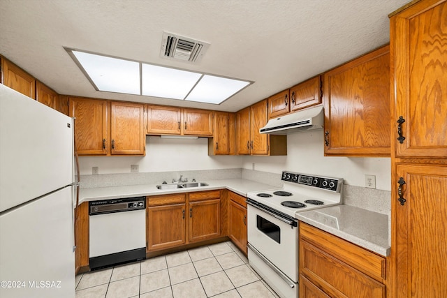 kitchen with sink, white appliances, light tile patterned floors, and a textured ceiling