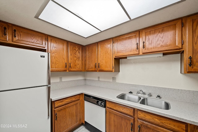 kitchen with sink, white appliances, and a skylight