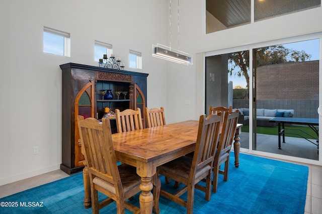 dining space with a healthy amount of sunlight and a high ceiling