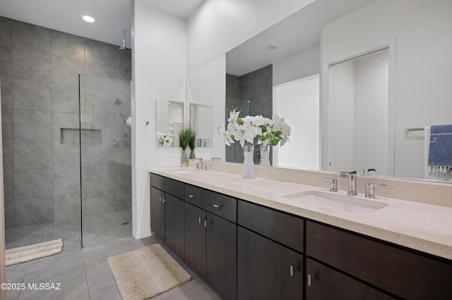 bathroom featuring tiled shower, tile patterned flooring, and vanity