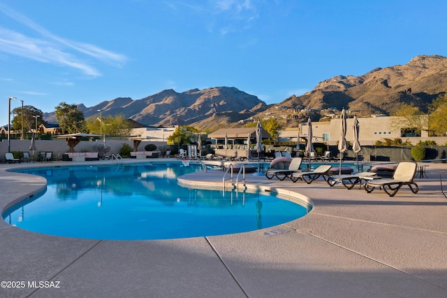 view of swimming pool with a patio area and a mountain view