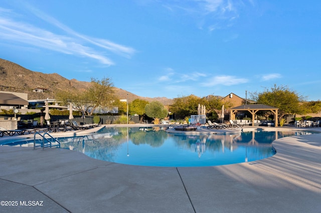 view of pool with a patio, a mountain view, and a gazebo