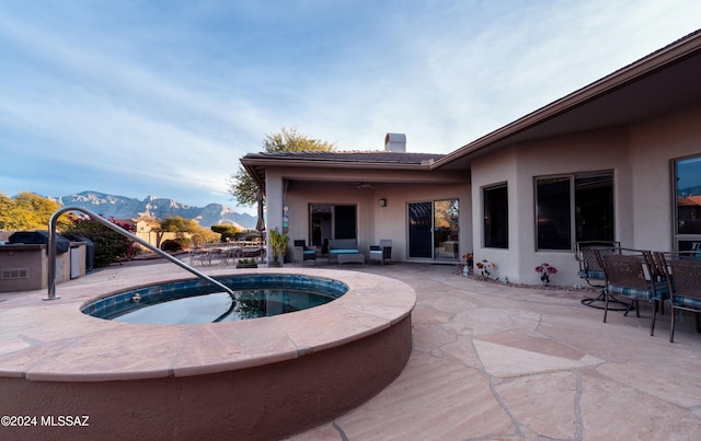 view of swimming pool featuring a patio area, a mountain view, grilling area, and an in ground hot tub