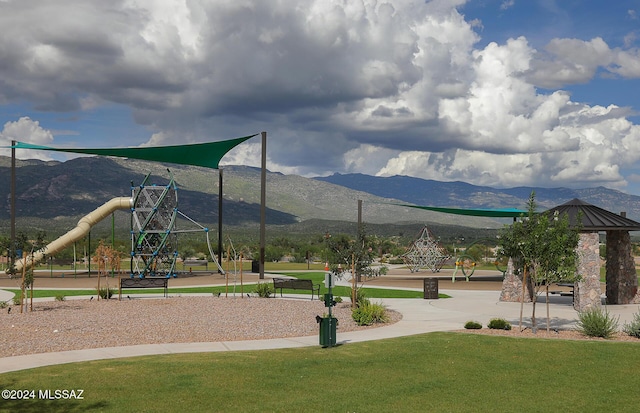 view of home's community with a lawn, a mountain view, and a playground