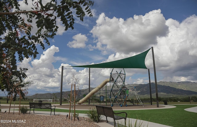 view of jungle gym featuring a mountain view and a yard