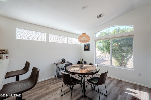 dining space with hardwood / wood-style flooring and lofted ceiling