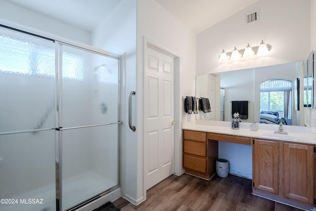 bathroom with hardwood / wood-style floors, vanity, an enclosed shower, and vaulted ceiling