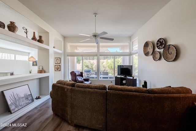 living room featuring built in features, ceiling fan, and dark wood-type flooring