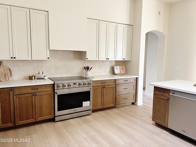 kitchen featuring white cabinetry, sink, stainless steel appliances, and decorative light fixtures