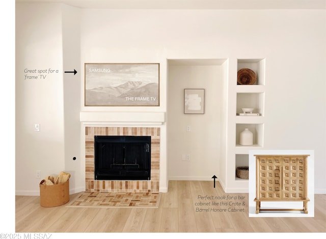 living room featuring hardwood / wood-style flooring, built in features, and a fireplace