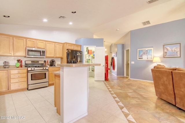 kitchen with a kitchen island, light tile patterned floors, stainless steel appliances, and light brown cabinetry