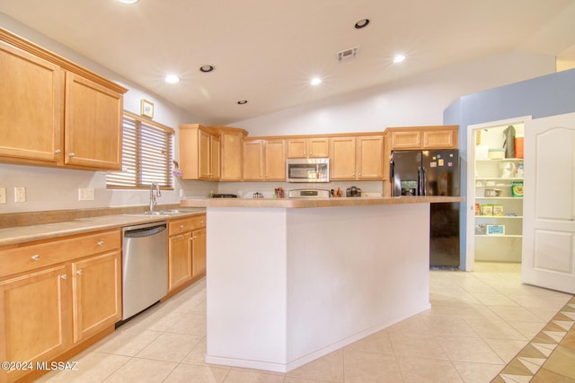 kitchen featuring light tile patterned flooring, lofted ceiling, sink, a kitchen island, and stainless steel appliances