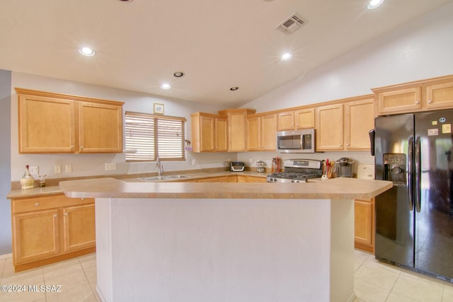 kitchen with a center island, sink, vaulted ceiling, light tile patterned flooring, and stainless steel appliances